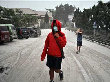 Indonesian students walk on a street covered with volcanic ash following an eruption of Mount Kelud, in Yogyakarta. AP