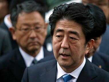 Shinzo Abe speaks to the media in front of Akio Toyoda after taking part in Toyota's driving car test in Tokyo. Reuters