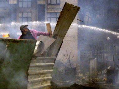 An anti-government protester throws a Molotov cocktail during clashes with riot police in Kiev. AP 