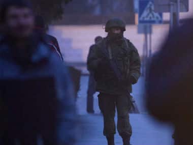 An armed man patrols a square in front of the airport in Simferopol, Crimea.  Associated Press. 