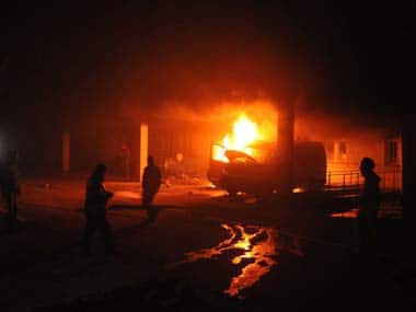 Ukrainian protesters burn a cars outside a Security Service headquarters in Lviv, western Ukraine, early Wednesday. AP