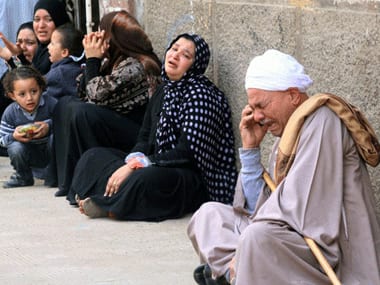 Egyptian relatives of supporters of ousted Islamist president Mohamed Morsi cry sitting outside the courthouse after the court ordered the execution of 529 Morsi supporters after only two hearings. AFP