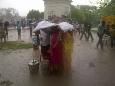 People taking shelter from the rain in the rally. Sandip Roy/Firstpost