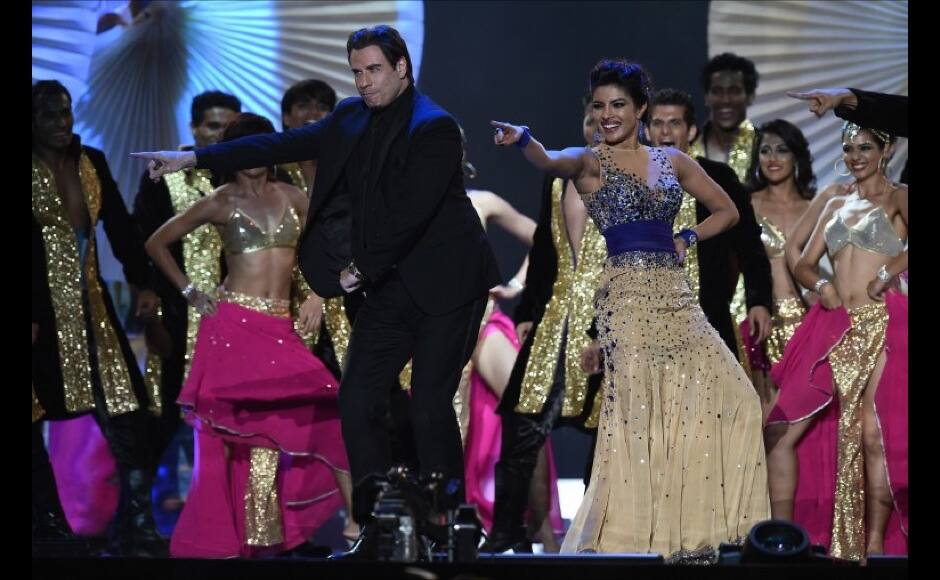 Bollywood actress Priyanka Chopra and US actor John Travota dance on stage at the Raymond James Stadium on the fourth and final day of the 15th International Indian Film Academy (IIFA) Awards in Tampa, Florida, April 26, 2014. AFP PHOTO JEWEL SAMAD
