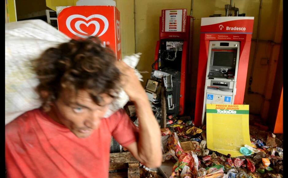 A man carries goods out of a supermarket that was looted during a police strike in Salvador, Bahia state, April 17, 2014. A police strike has unleashed violent crime in Brazil's third-largest city just two months before it is set to welcome hordes of soccer fans for the World Cup, adding to fears about the country's ability to ensure safety during the event. At least 22 people were killed in and around the northeastern city of Salvador after state police went on strike early on Wednesday to demand better pay and other benefits, the Bahia state government said on Thursday, prompting the federal government to dispatch troops to restore order. REUTERS