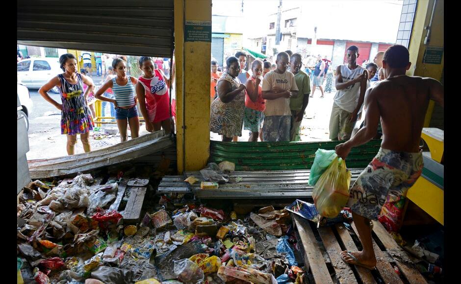 A man carries goods out of a supermarket that was looted during a police strike in Salvador, Bahia state, April 17, 2014. A police strike has unleashed violent crime in Brazil's third-largest city just two months before it is set to welcome hordes of soccer fans for the World Cup, adding to fears about the country's ability to ensure safety during the event. At least 22 people were killed in and around the northeastern city of Salvador after state police went on strike early on Wednesday to demand better pay and other benefits, the Bahia state government said on Thursday, prompting the federal government to dispatch troops to restore order. REUTERS