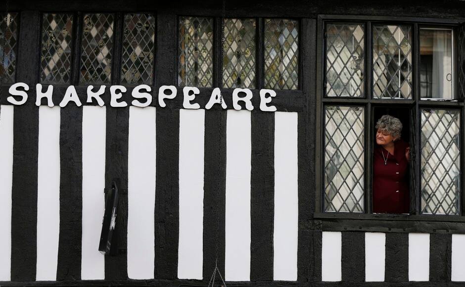 A woman looks out a window as a procession marking the 450th anniversary of William Shakespeare's birth passes by in Stratford-upon-Avon, southern England April 26, 2014. Shakespeare's birthplace of Stratford-upon-Avon is hosting a weekend of festivities in celebration of their famous son who was regarded as England's greatest playwright. REUTERS/Suzanne Plunkett
