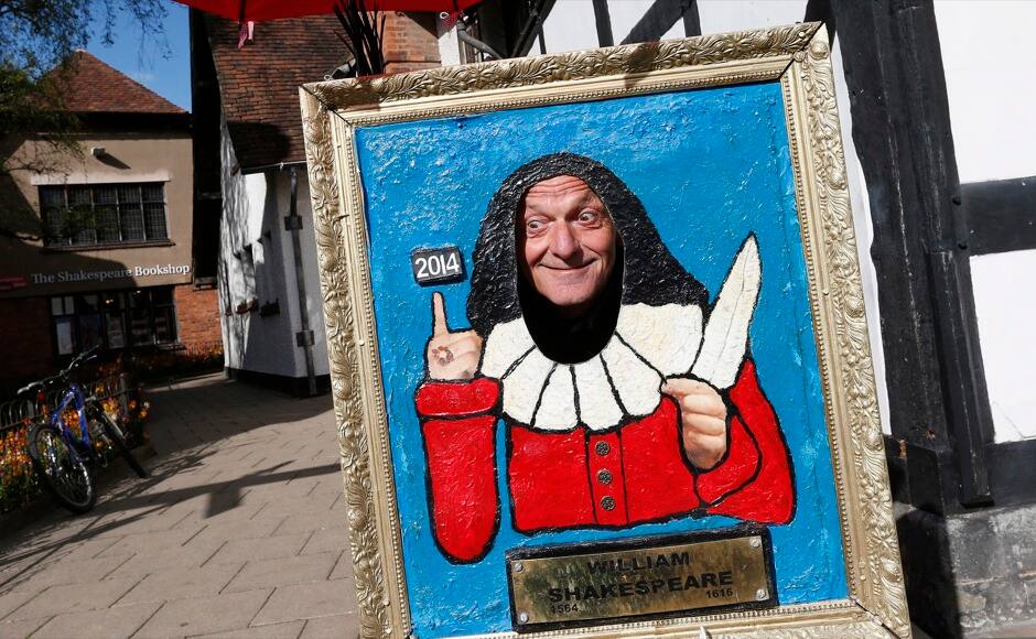 A visitor poses for a photograph outside the birthplace of William Shakespeare on the 450th anniversary of his birth in Stratford-upon-Avon, southern England April 26, 2014. Shakespeare's birthplace of Stratford-upon-Avon is hosting a weekend of festivities in celebration of their famous son who was regarded as England's greatest playwright. REUTERS/Suzanne Plunkett 