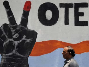 A man walks past a poster on voting awareness. AFP 