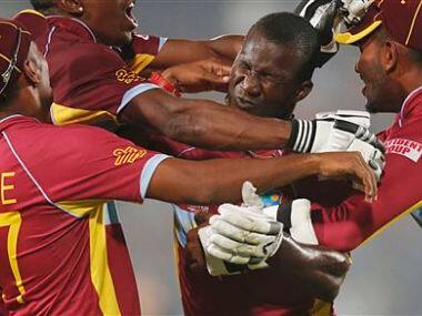 West Indies' players pounce on captain Darren Sammy, second right, to celebrate their win over Australia. AP