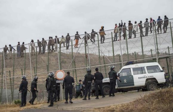 Hundreds of migrants storm across Spanish border at Melilla Hundreds of migrants storm across Spanish border at Melilla
