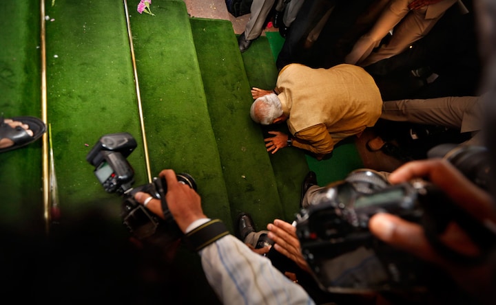 Photos: He stoops to conquer? Modi prays before Parliament stairs