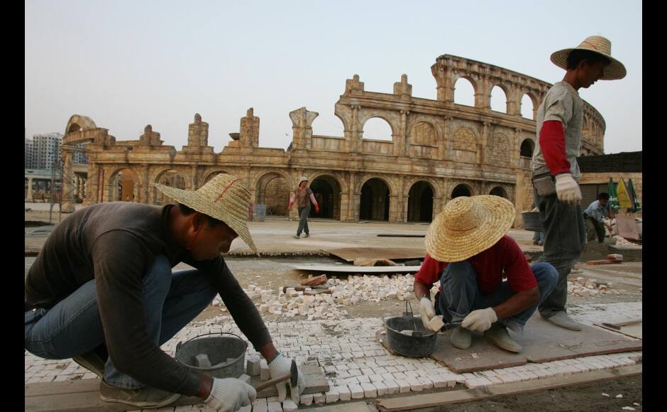 Workers build a pavement outside a replica of the Roman Colosseum at the Fisherman's Wharf, a local invested entertainment park with a casino, which is under construction at the Outer Harbour area in Macau October 19, 2005. Companies around the world are pumping billions of dollars into this former Portuguese enclave to build new casinos, hotels and shopping malls to tap a growing flood of Chinese tourists. The territory is the only place in China where casinos are legal. Photo taken October 19. REUTERS