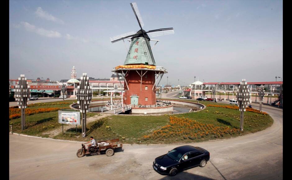 A car drives on a roundabout with a windmill in the middle in 