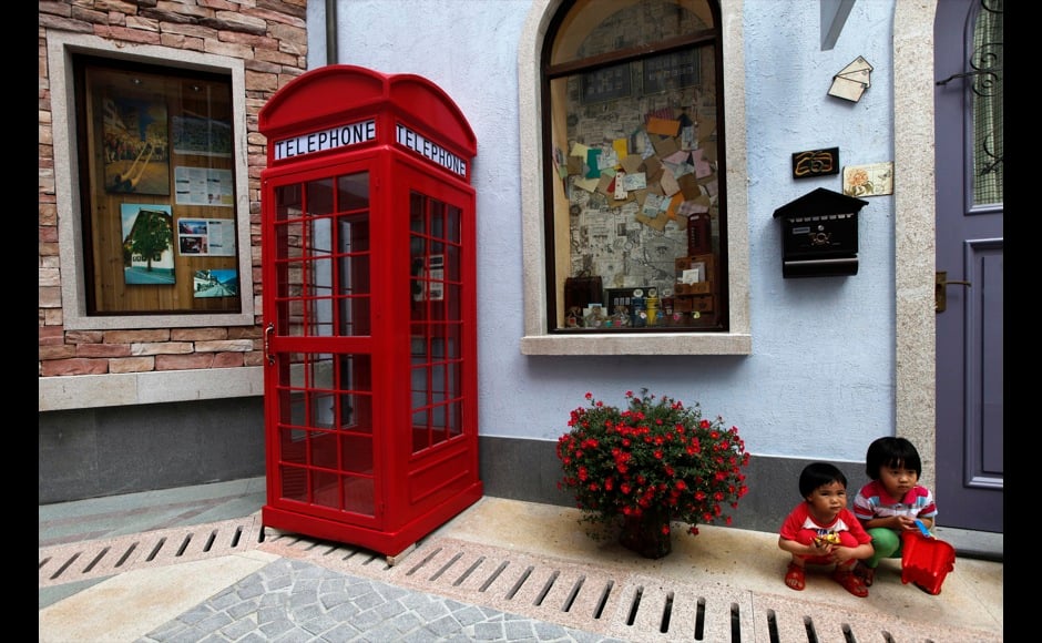 Children pose for pictures at the replica of Austria's UNESCO heritage site, Hallstatt village, in China's southern city of Huizhou in Guangdong province June 1, 2012. Metals and mining company China Minmetals Corporation spent $940 million to build this controversial site and hopes to attract both tourists and property investors alike, according to local newspaper reports. REUTERS