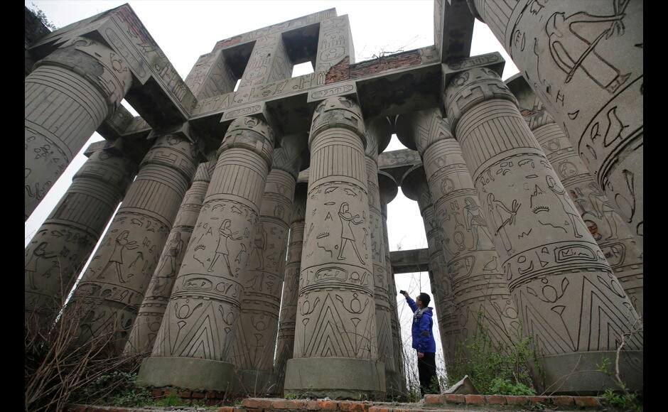 A visitor takes a photograph of a carved structure, which is a replica of the Karnak Temple in Egypt, at the abandoned Wanguo park in Wuhan, Hubei province March 12, 2013. The park was abandoned during the course of construction 14 years ago, according to local media. REUTERS