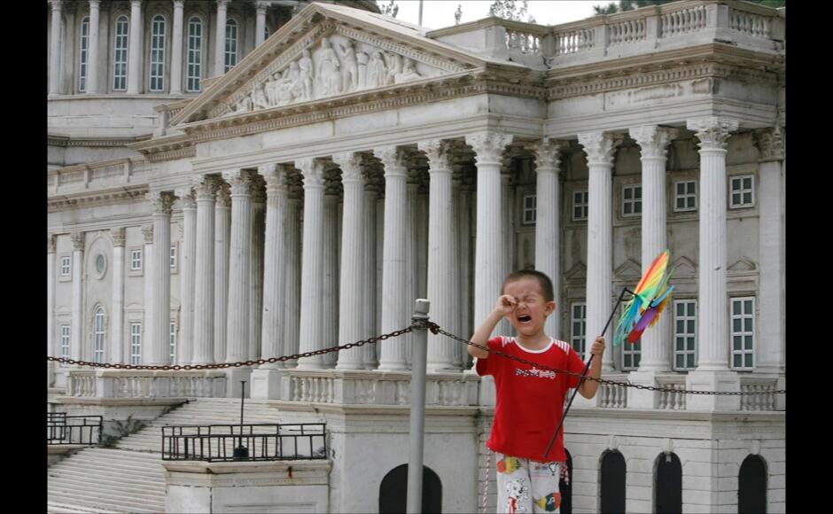 A boy cries near a replica of the United States Capitol building at Beijing World Park, one of three designated 