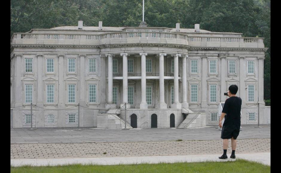 A visitor takes photographs of a replica of the White House at Beijing World Park, one of the three designated 