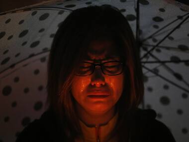 A woman cries while praying during a candlelight vigil to commemorate the victims of the sunken ferry Sewol. Reuters