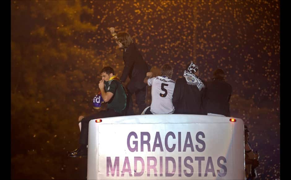 Real Madrid's goalkeeper Iker Casillas, left celebrates with Luka Modric, 2nd left on top of an open-deck bus in Madrid, Spain, Sunday, May 25, 2014 after their team won the Champions League final soccer match in Lisbon by beating Atletico Madrid. AP
