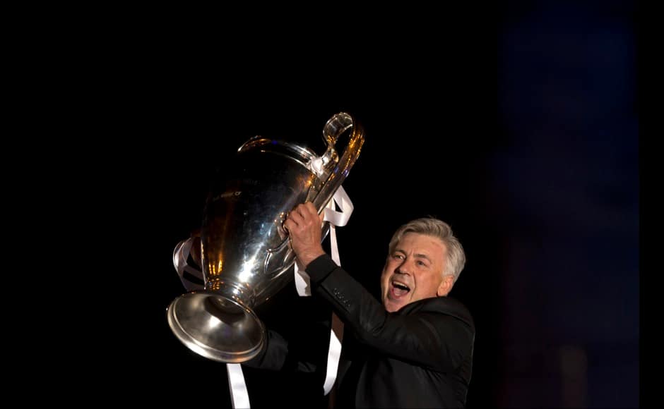 Real Madrid's Carlo Ancelotti shows the trophy to the fans in Madrid, Spain, Sunday, May 25, 2014 after their team won the Champions League final soccer match in Lisbon by beating Atletico Madrid. AP
