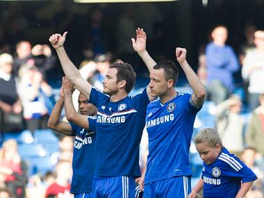 Chelsea's John Terry, right, Frank Lampard, center, and Joe Cole salute the fans as they walk around the pitch with their children at the end of their English Premier League soccer match against Norwich City. AP