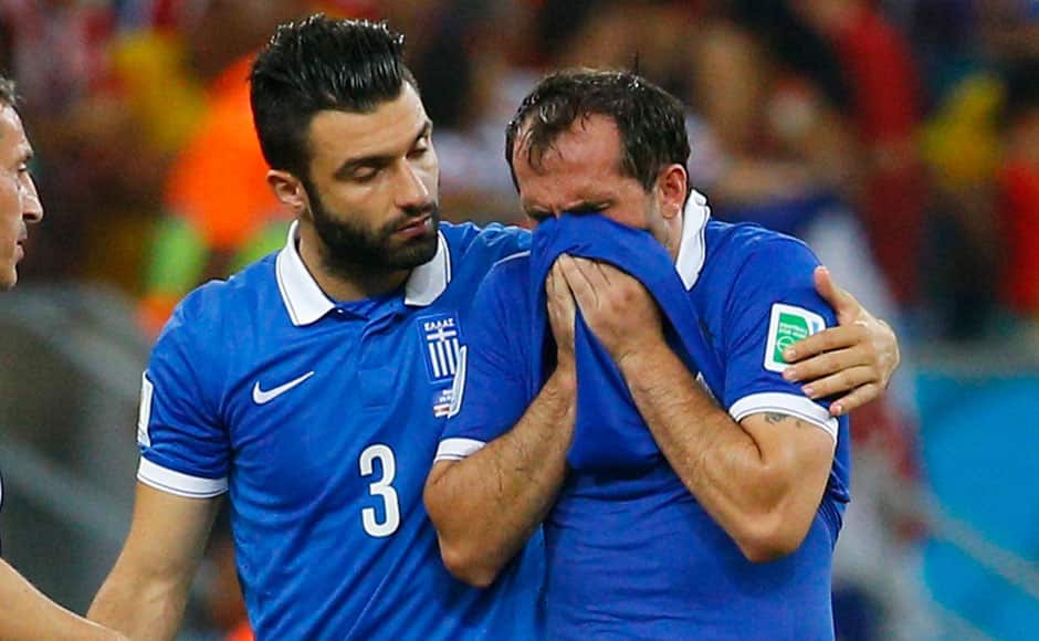 Greece's Theofanis Gekas (R) is consoled by Giorgios Tzavellas after losing their 2014 World Cup round of 16 game against Costa Rica at the Pernambuco arena in Recife June 29, 2014. REUTERS