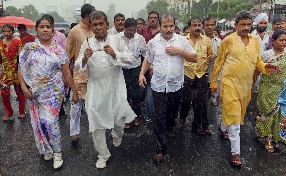 Kolkata Pradesh Congress President Adhir Ranjan Chowdhury and other leaders get drenched in the rain during a rally to protest against the rail fare hike in Kolkata on Wednesday. PTI