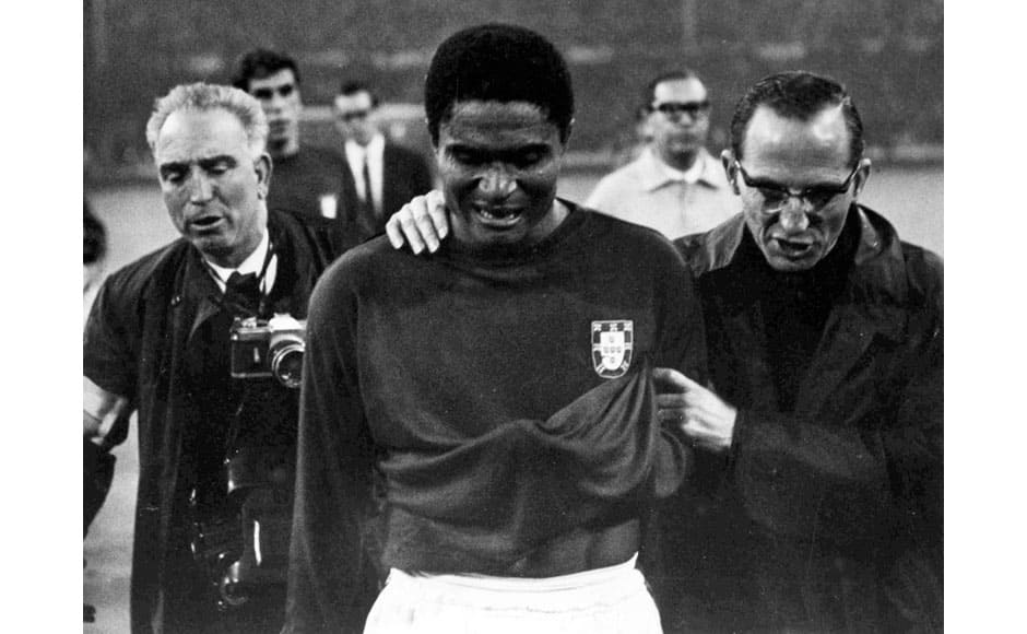 In this July 26, 1966 file photo, Portugal's star player Eusebio is led from the pitch in tears after England defeated Portugal 2-1 in the semifinal of the World Cup at Wembley, London. Of all the spectacular moments in Eusebio's two-decade career, perhaps the most memorable was the Portuguese comeback he inspired against North Korea in the quarterfinals of the 1966 World Cup in England. After Portugal fell 3-0 behind, Eusebio scored four goals in just over 30 minutes, demonstrating the athletic prowess and sure-eyed finishing that made him one of the world's top scorers during his heyday in the 1960s. Born into poverty in Africa, Eusebio became known as the Black Panther for his agility and hard-charging attacks. He was awarded the Ballon d'Or in 1965 and twice won the Golden Boot - in 1968 and 1973 - for being top scorer in Europe. He died in January. AP