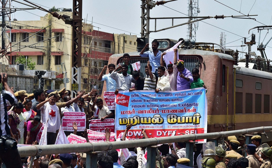 AIDWA-DYFI-SFI activists stop a train and shout slogans during a protest against the hike in rail fares at the Central railway station in Chennai on Wednesday. PTI