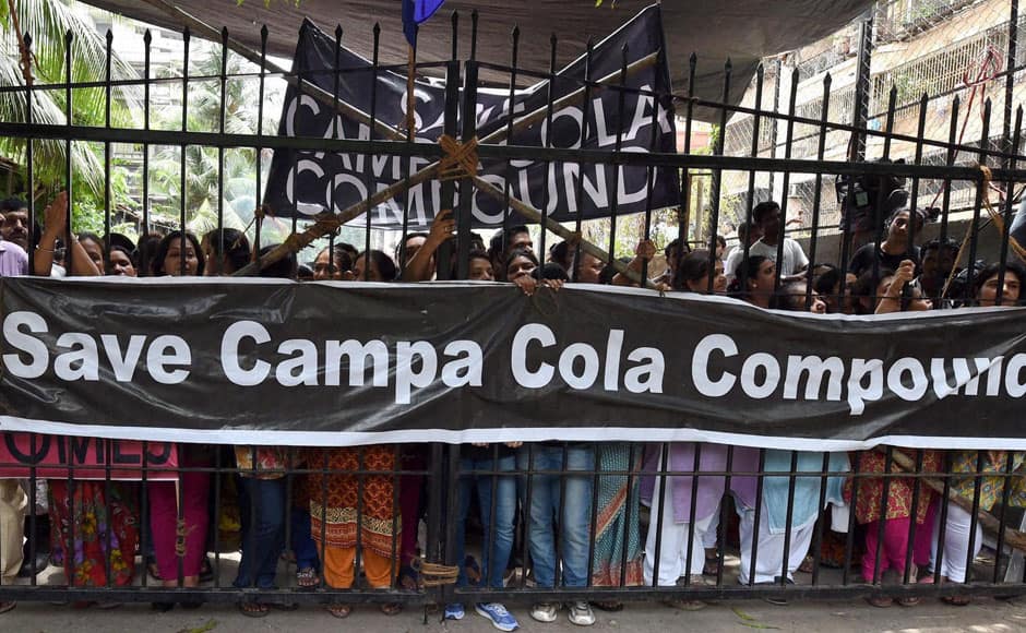 Campa Cola residents block the entrance for the BMC officials who arrived to disconnect the water and electricity supply of the society, in Mumbai on Saturday. PTI
