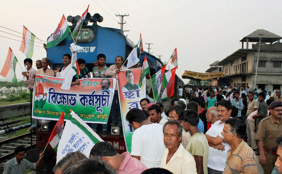 Congress activists stop a train and raise slogans during a protest against rail fare hike at Balurghat Railway station in West Bengal on Wednesday. PTI