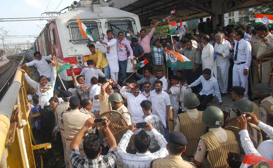 Congress workers stop the train protesting against train fare hike at Surat Railway Station in Surat. PTI
