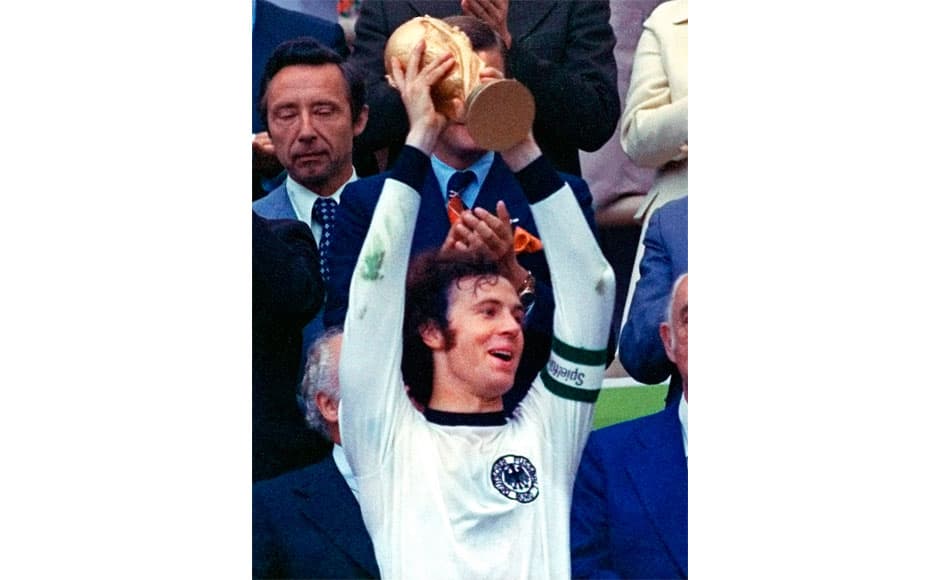 In this July 7, 1974 file photo, West Germany's Franz Beckenbauer, holds up the World Cup trophy after they defeated the Netherlands 2-1 in the World Cup soccer final at Munich's Olympic stadium in Germany. With one week to go before the World Cup starts in Brazil, The Associated Press takes a look at 10 great stars in the tournament's history. Beckenbauer defined the role of libero and his elegant and effortless style earned him the nickname the Kaiser. Beckenbauer won every club honor with Bayern Munich, including three straight Champions Cup titles, and is the only man to captain (in 1974) and coach (1990) a team to the World Cup title. Beckenbauer made 103 appearances for Germany and is considered the football power's best player of all time. He also served as coach and president of Bayern. At 68, he has given up official functions but still works for television and remains vastly popular in Germany. AP