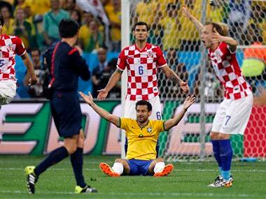 Brazil's Fred sits on the pitch as Croatian players Vedran Corluka (5), Dejan Lovren (6) protest. AP
