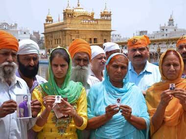Relatives of Indian workers who were taken hostage in Iraq pose with photographs of their loved ones at the Golden Temple in Amritsar on 19 June 2014. AFP