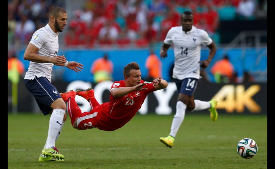 Karim Benzema (L) watches as Switzerland's Xherdan Shaqiri falls to the ground in front of him as they fight for the ball. Reuters