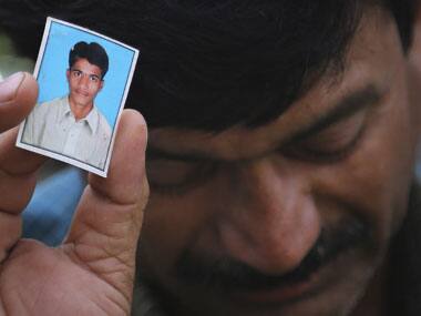 Bonath Shekar Naik shows a portrait of his son Rambabu, one of the missing students in the Beas river mishap. AP