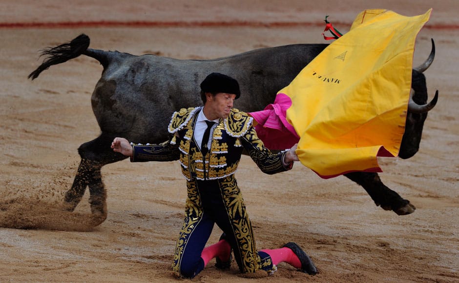 Bullfighter Manuel Escribano performs a pass during a bullfight at the Plaza de Toros during the San Fermin festival in Pamplona July 13, 2014. The festival, a heady mix of drinking, dancing, late nights and bullfights, made famous by Ernest Hemingway in his novel 