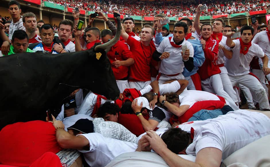 A fighting cow leaps over festival goers as she enters the ring during the San Fermin festival in Pamplona July 13, 2014. REUTERS