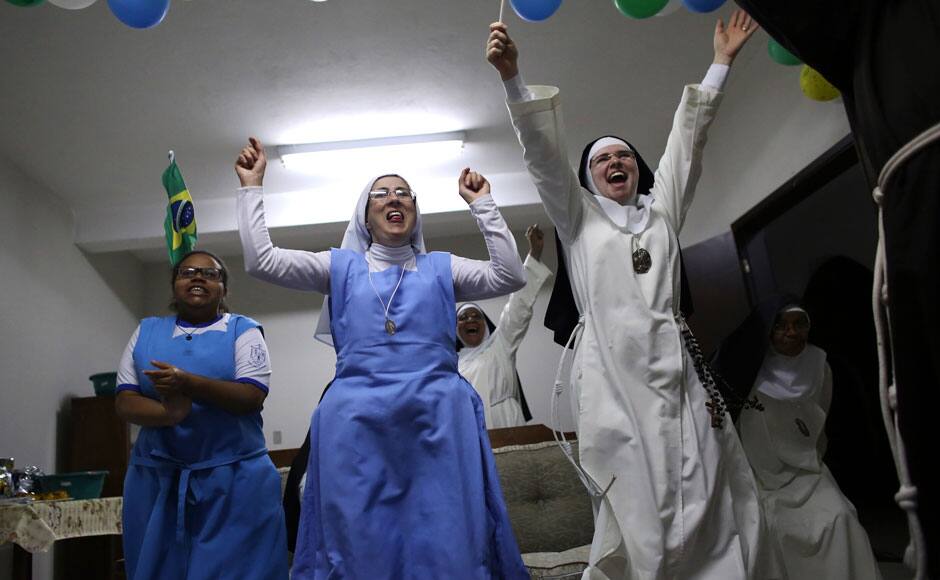 Nuns from the enclosed monastery of Imaculada Conceicao celebrate Brazil's victory as they watch on television at the end of the 2014 World Cup quarter-final soccer match between Brazil and Colombia in Piratininga, in Sao Paulo state. Reuters