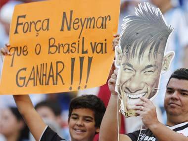 Fans hold a cutout showing Brazilian player Neymar with a sign that reads in Portuguese '