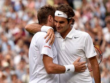 Roger Federer (R) embraces Stanislas Wawrinka after defeating him in quarter-final at the Wimbledon. Reuters