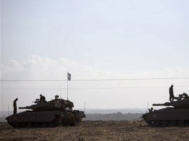 Israeli soldiers are seen on tanks near the Gaza Strip. AP 