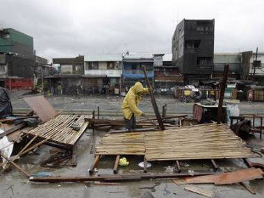 A man salvages what is left of his makeshift house as Typhoon Rammasun batters suburban Navotas, north of Manila, Philippines. AP 
