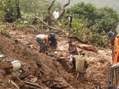 Rescue workers carry the body of a victim at the landslide site. PTI