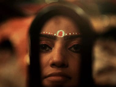 An actor is reflected in a mirror as she prepares backstage for a performance of the Ramlila. AFP