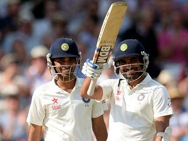 Mohammed Shami (R) waves his bat after reaching his half century as he stands with team-mate Bhuvneshwar Kumar. Reuters