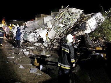 Rescue workers survey the wreckage of TransAsia Airways flight GE222 which crashed while attempting to land in stormy weather on the Taiwanese island of Penghu, late Wednesday. AP