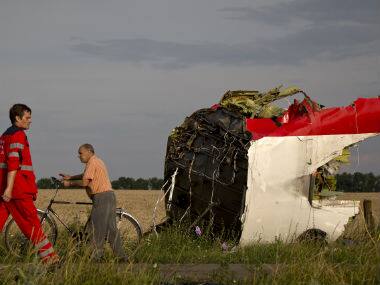 A paramedic walks by a part of fuselage at the crash site of Malaysia Airlines Flight 17 near the village of Hrabove, eastern Ukraine. AP 